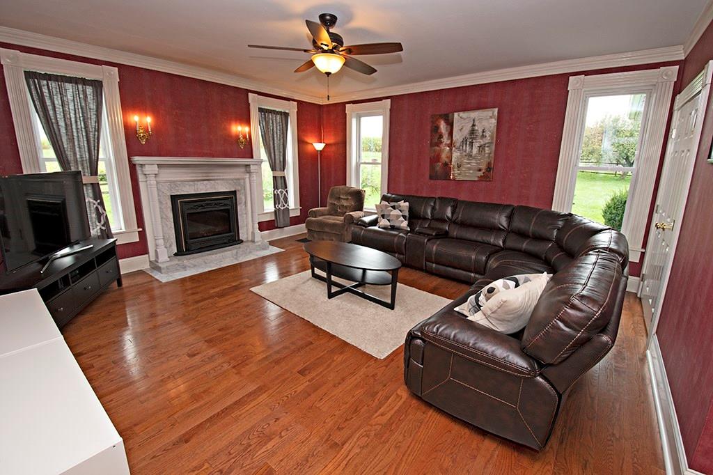 354 Scott Ridge Road Harmony, PA 16037 - Photo 3 of 22 Living room family room with storage,hardwood floors,Propane gas firplace, and ceiling fan.