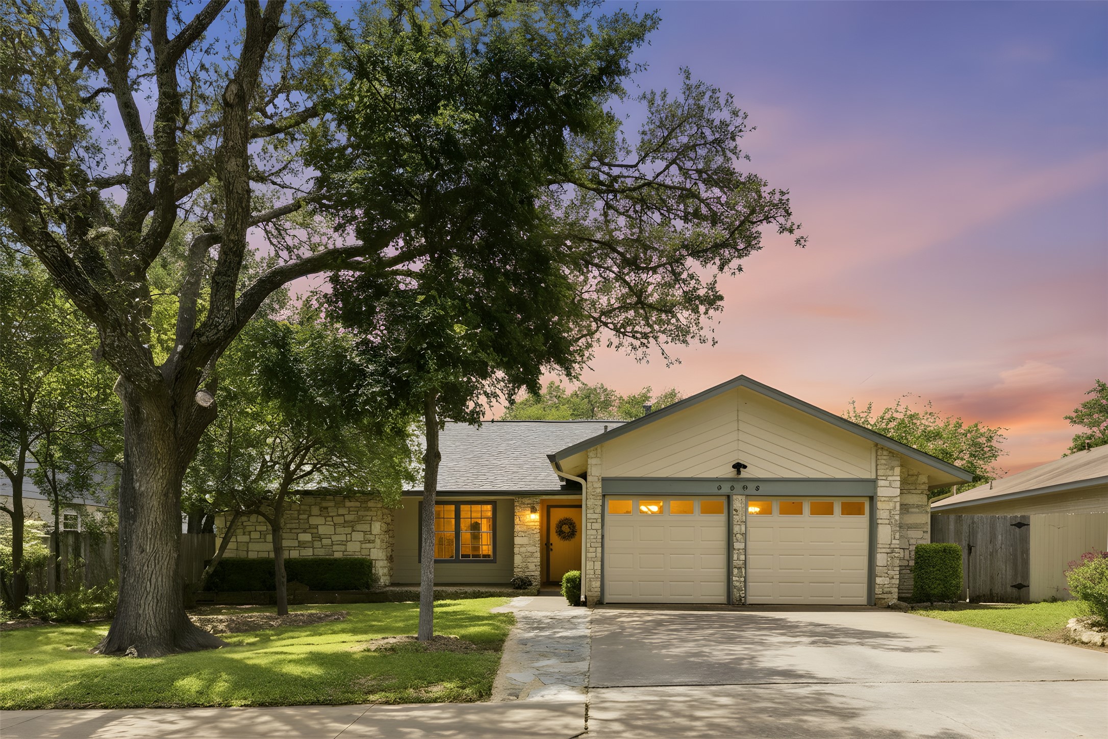 Stone and siding facade featuring a two-car garage with panel doors
