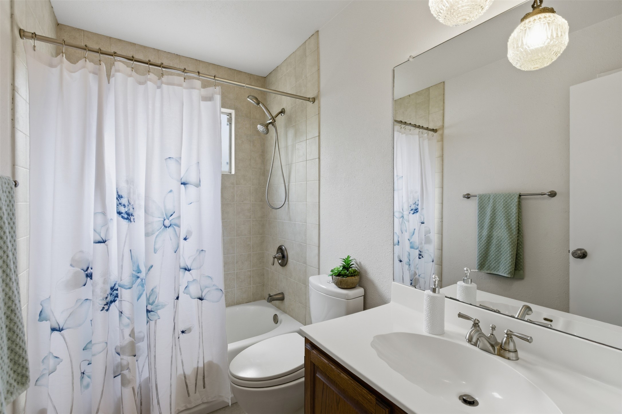 5305 Wolf Run Austin, TX 78749 - Photo 11 of 37 Bathroom featuring a full vanity with an integrated sink, broad wall-mounted mirror, and overhead decorative lighting