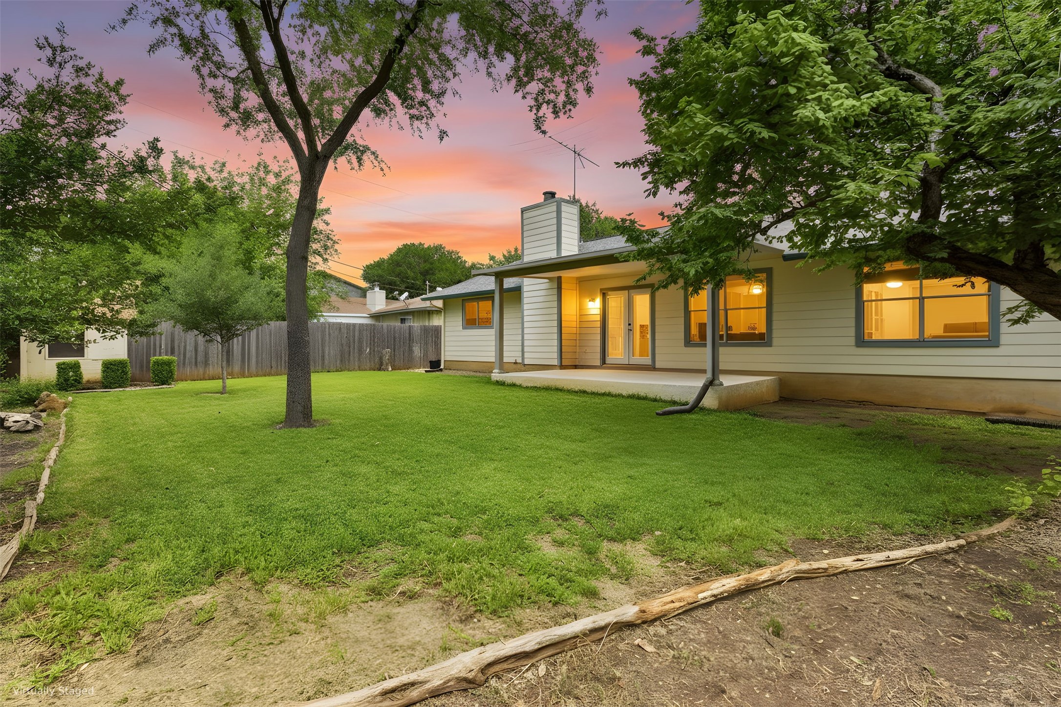 5305 Wolf Run Austin, TX 78749 - Photo 14 of 37 Rear exterior featuring a spacious lawn, mature trees, a concrete patio, and a wood privacy fence