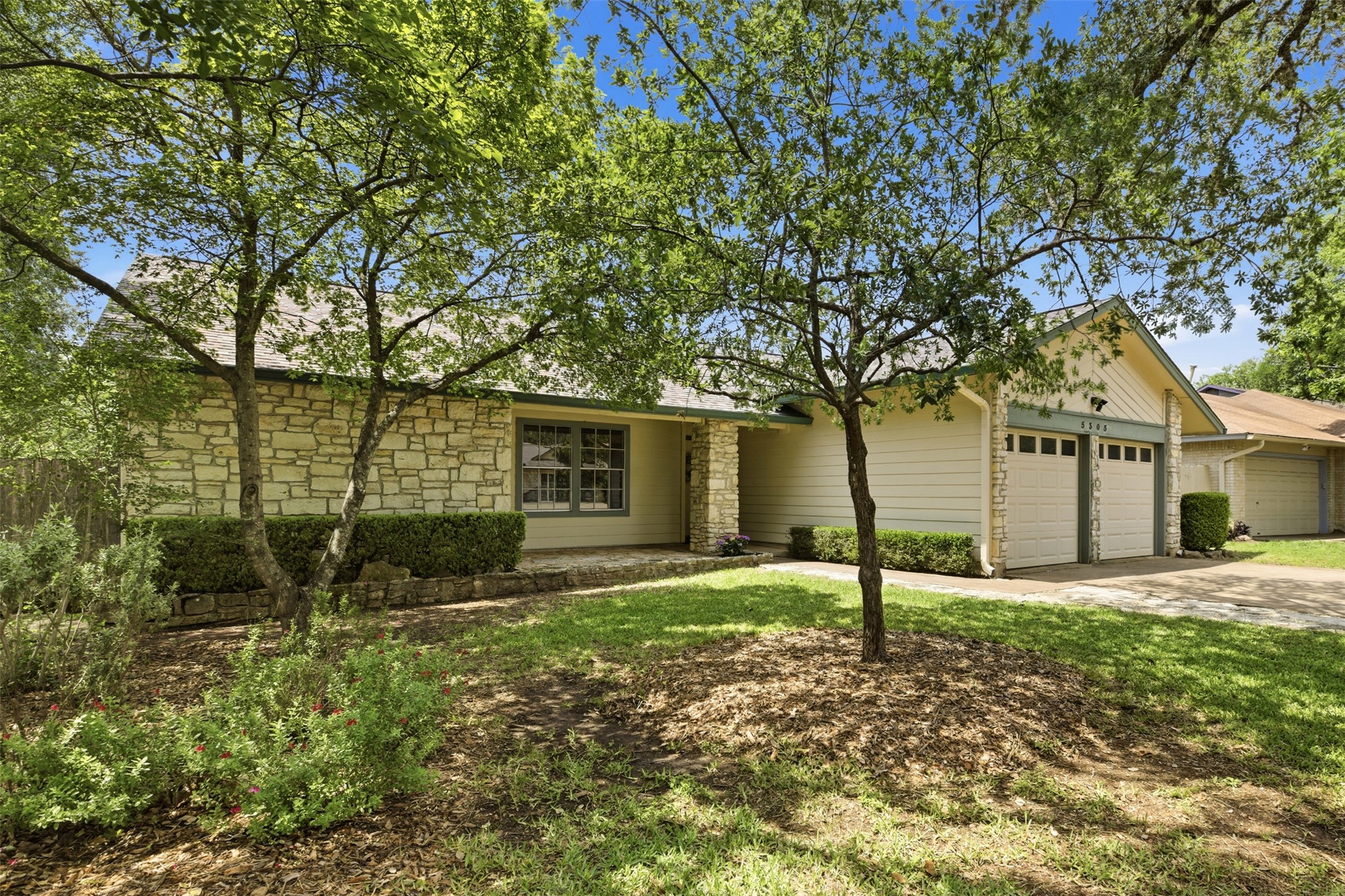 5305 Wolf Run Austin, TX 78749 - Photo 16 of 37 Single-story residence featuring stone and siding exterior, a two-car garage, and mature front yard trees