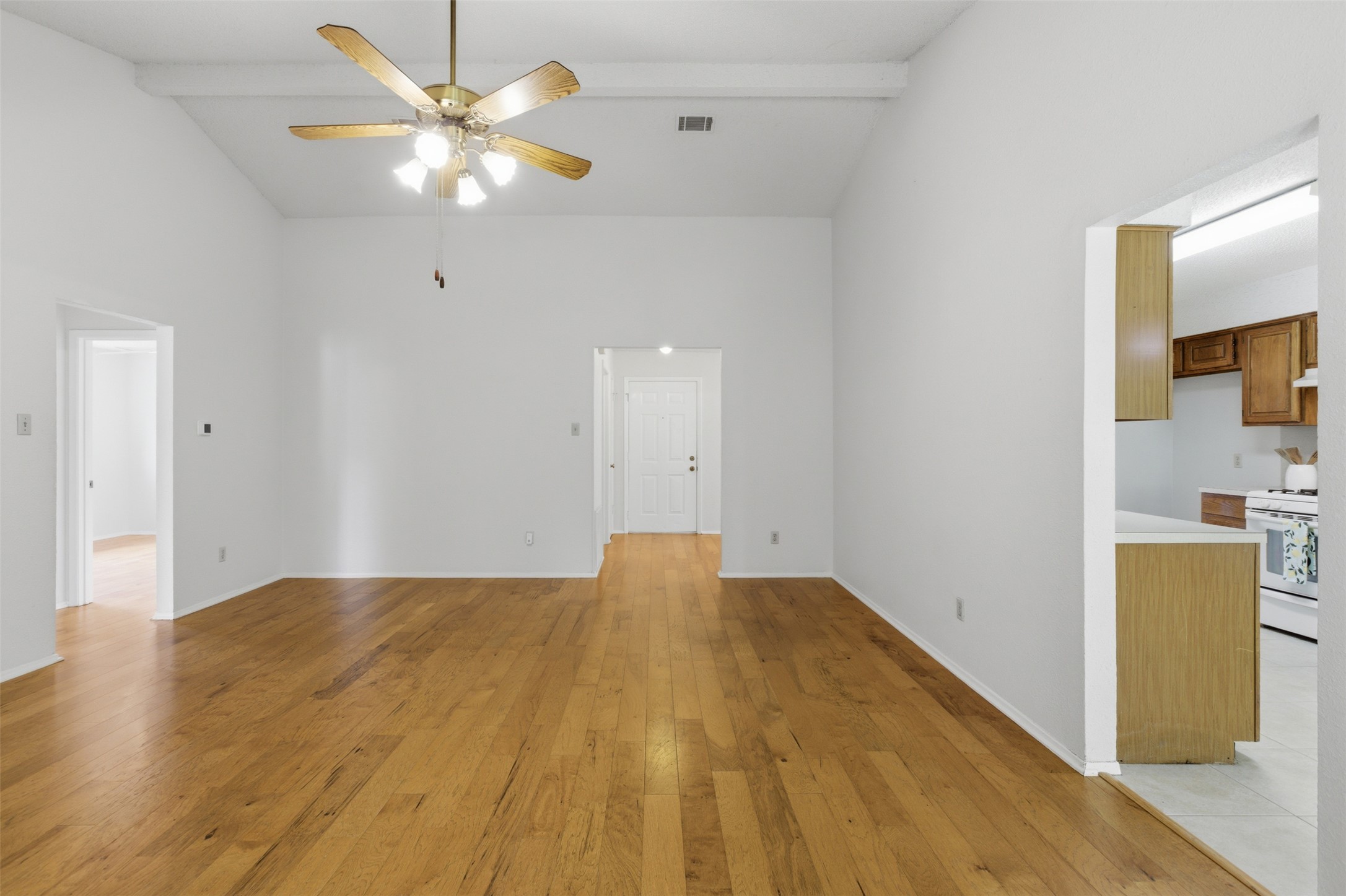 5305 Wolf Run Austin, TX 78749 - Photo 19 of 37 Spacious room featuring wood-finish flooring, vaulted ceilings with exposed beams, and a ceiling fan