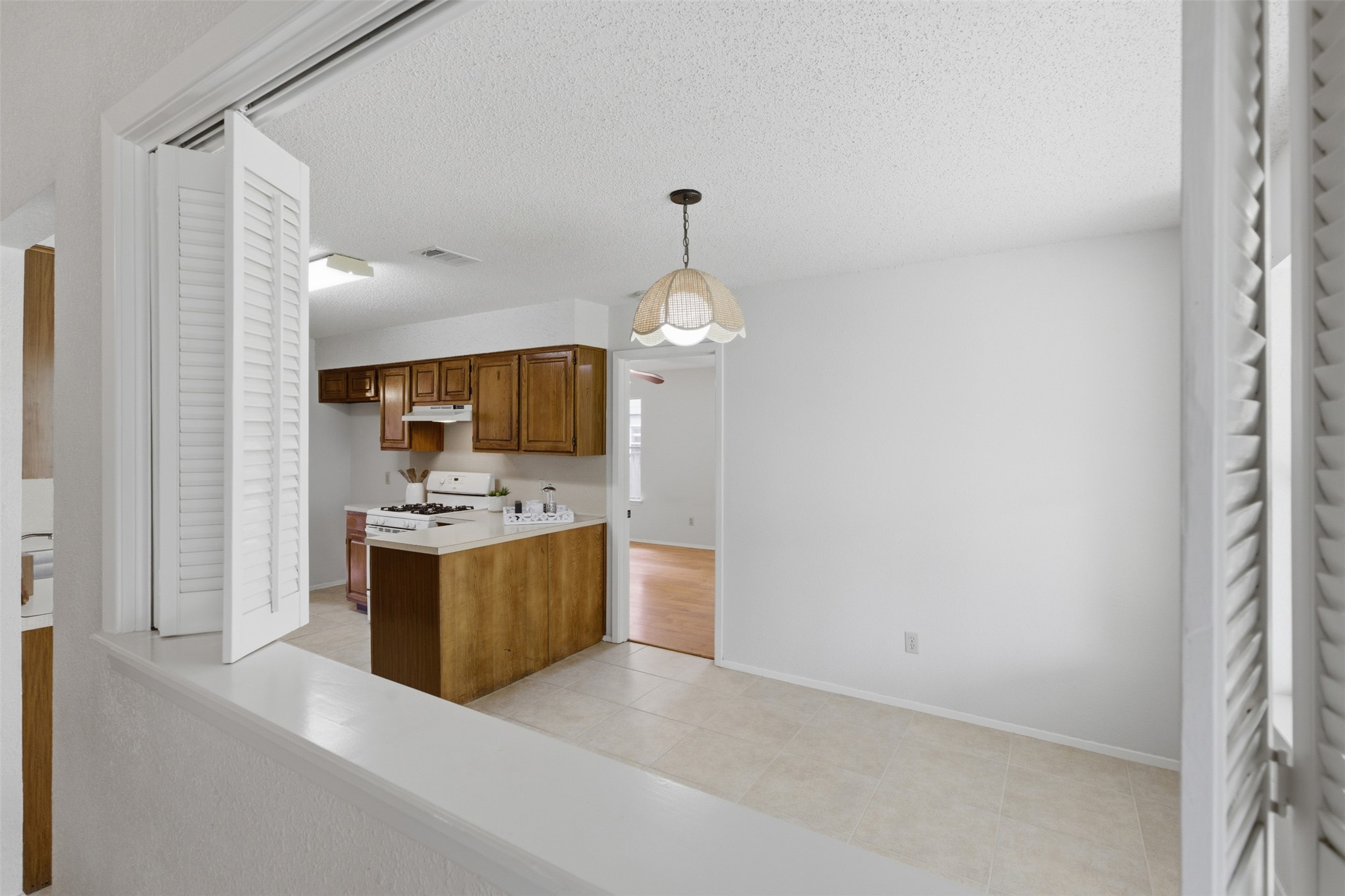 5305 Wolf Run Austin, TX 78749 - Photo 20 of 37 Kitchen area featuring wood cabinetry, white appliances, and a gas range