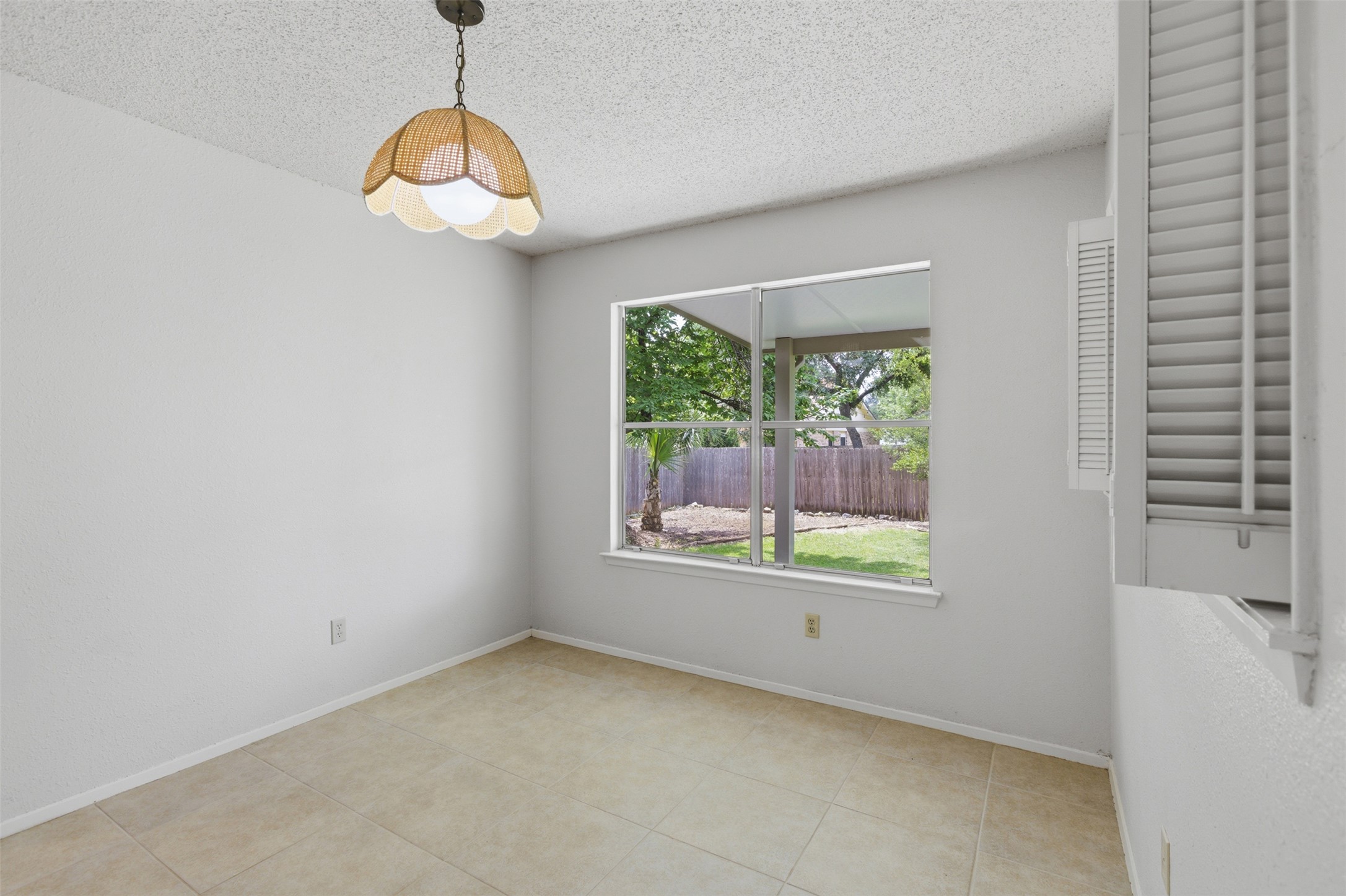 5305 Wolf Run Austin, TX 78749 - Photo 21 of 37 Room featuring neutral wall paint, tile flooring, and a large window with exterior backyard views