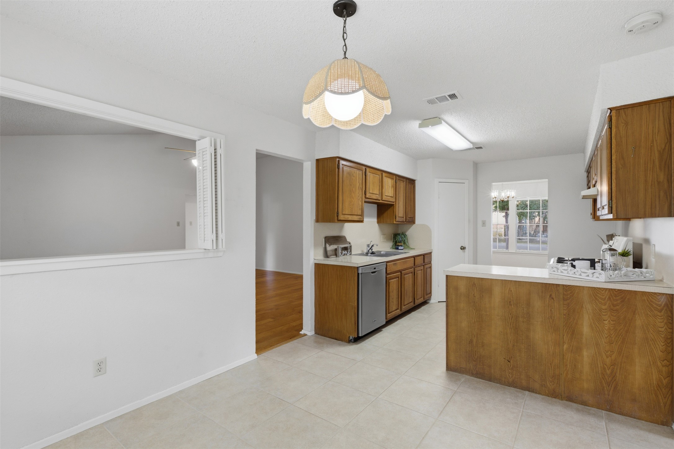 5305 Wolf Run Austin, TX 78749 - Photo 23 of 37 Kitchen featuring light wood cabinetry, white countertops, stainless steel dishwasher, and tile flooring