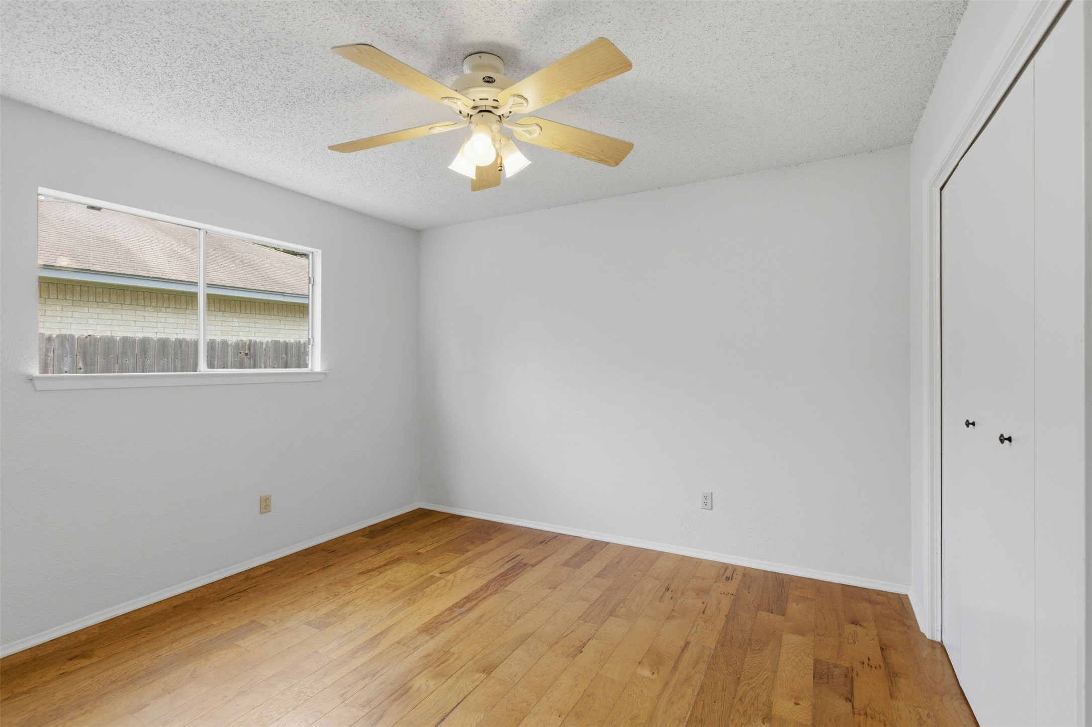 5305 Wolf Run Austin, TX 78749 - Photo 28 of 37 Room featuring wood-finish flooring, a ceiling fan with integrated lighting, and a window with a white frame