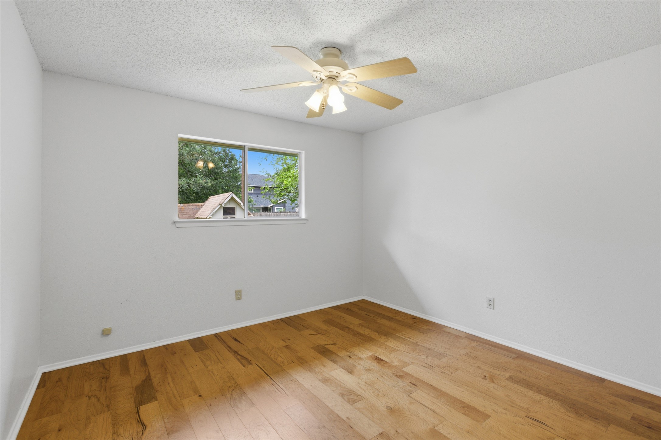 5305 Wolf Run Austin, TX 78749 - Photo 29 of 37 Room featuring wood-finish flooring, a ceiling fan with light fixture, and a window with exterior views