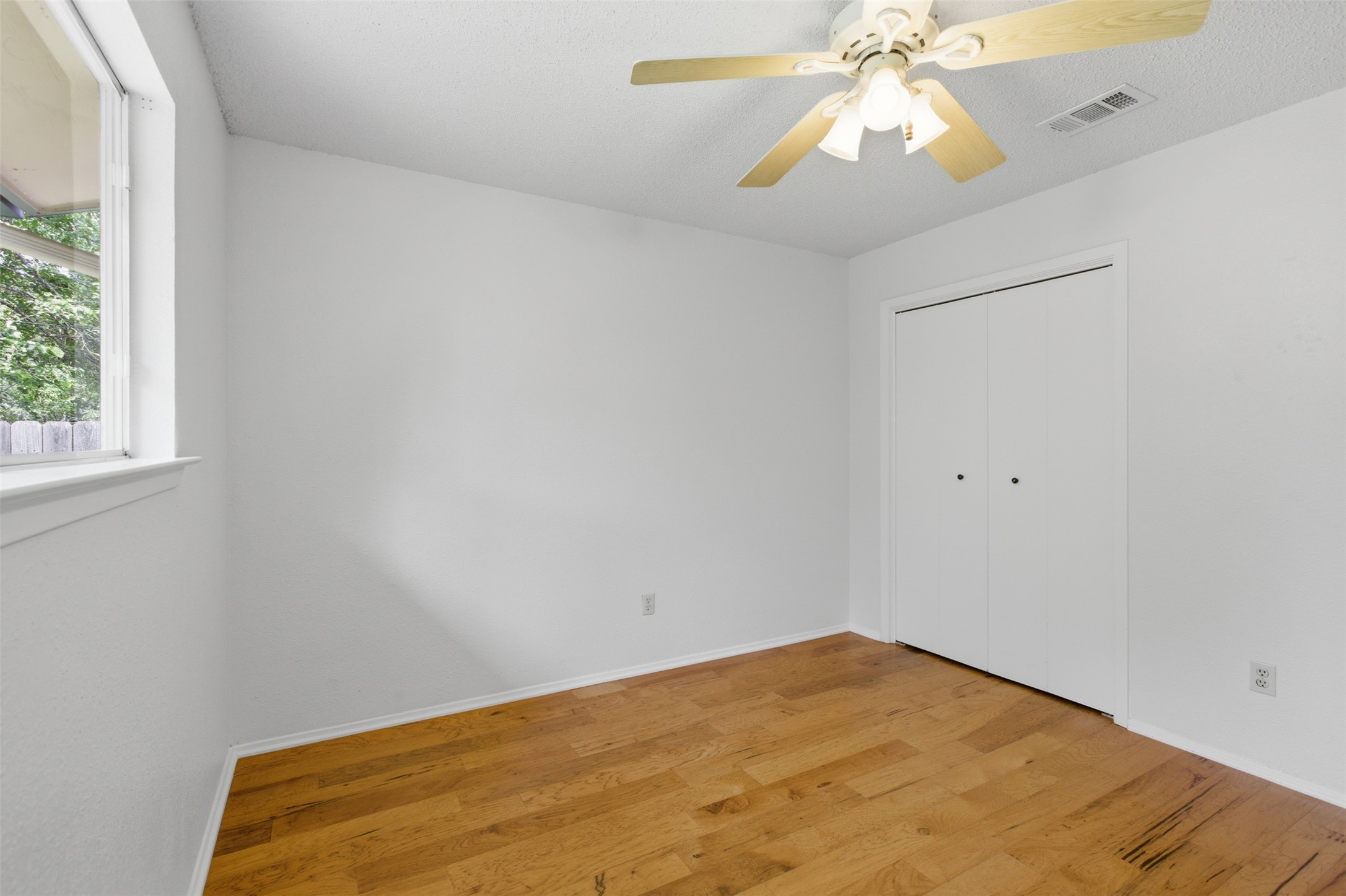 5305 Wolf Run Austin, TX 78749 - Photo 30 of 37 Room with wood-finish flooring, a double-door closet, and a ceiling fan with light fixture