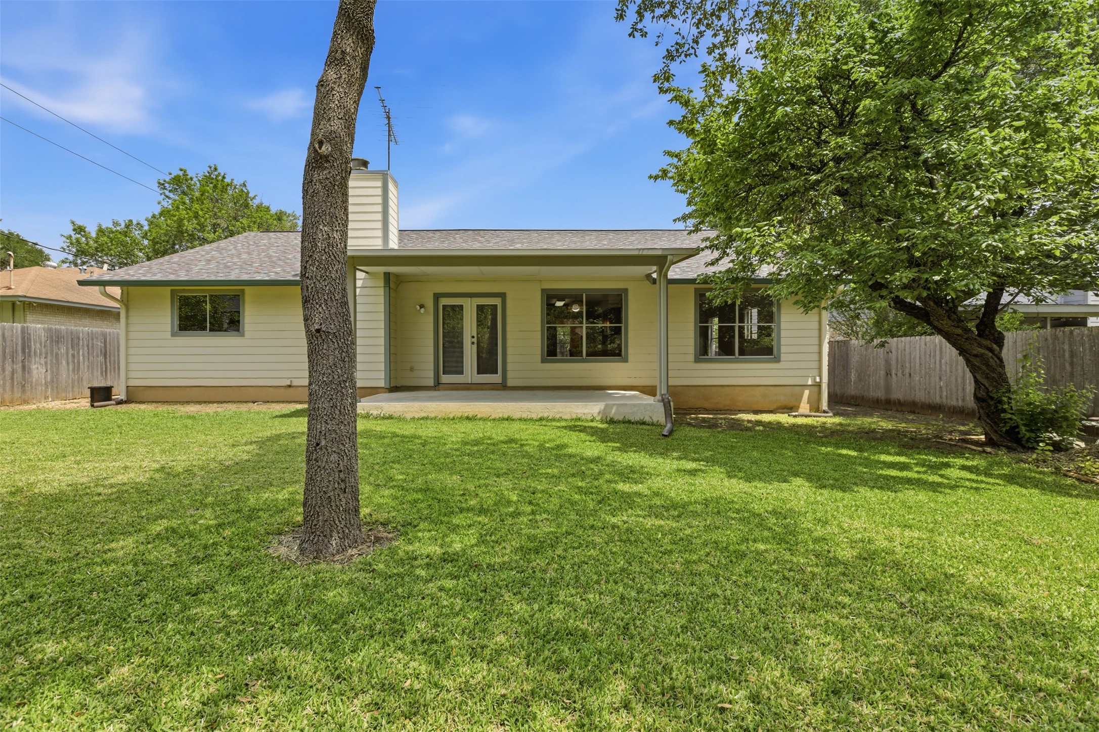 5305 Wolf Run Austin, TX 78749 - Photo 35 of 37 Expansive backyard featuring a lush lawn, mature trees, and a covered patio