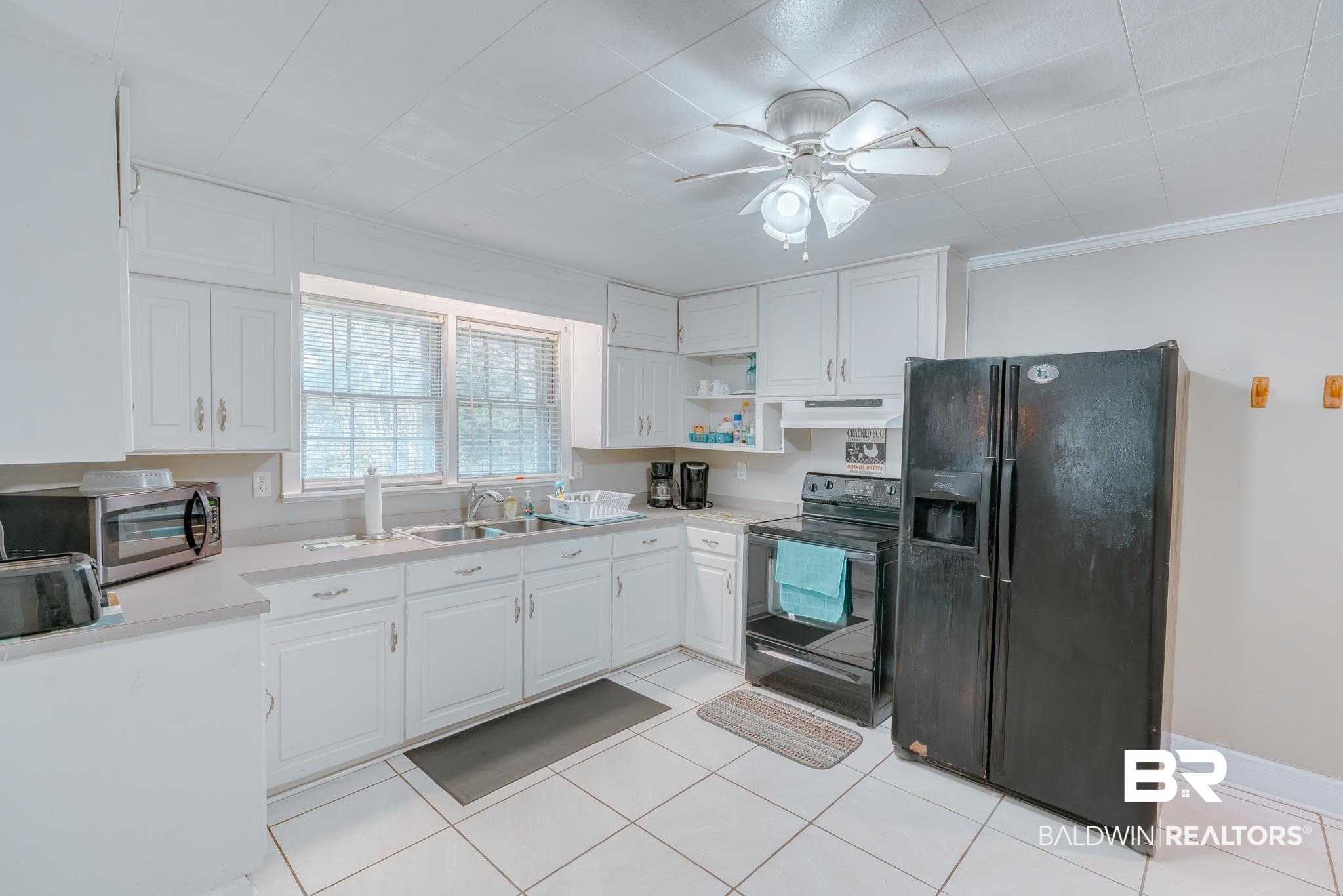 315 Fourth Avenue Chickasaw, AL 36611 - Photo 19 of 28 Kitchen featuring black appliances, under cabinet range hood, white cabinetry, light countertops, and a ceiling fan