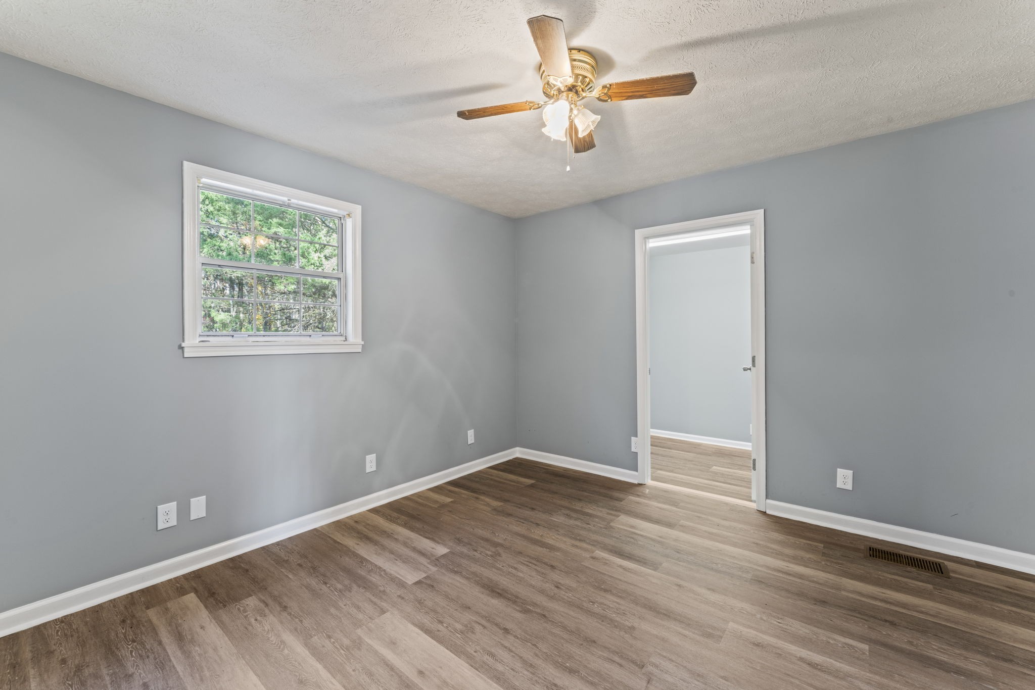 7736 Dice Lampley Road Fairview, TN 37062 - Photo 19 of 27 an empty room with wooden floor chandelier fan and windows