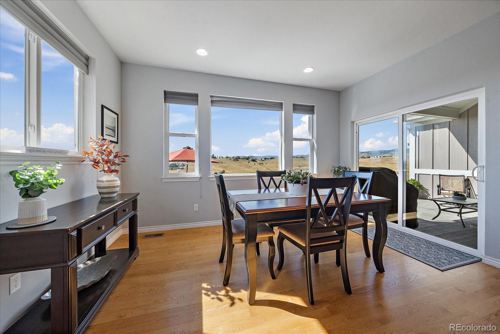 8412 Quaker Circle Arvada, CO 80007 - Photo 18 of 44 a view of a dining room with furniture window and wooden floor