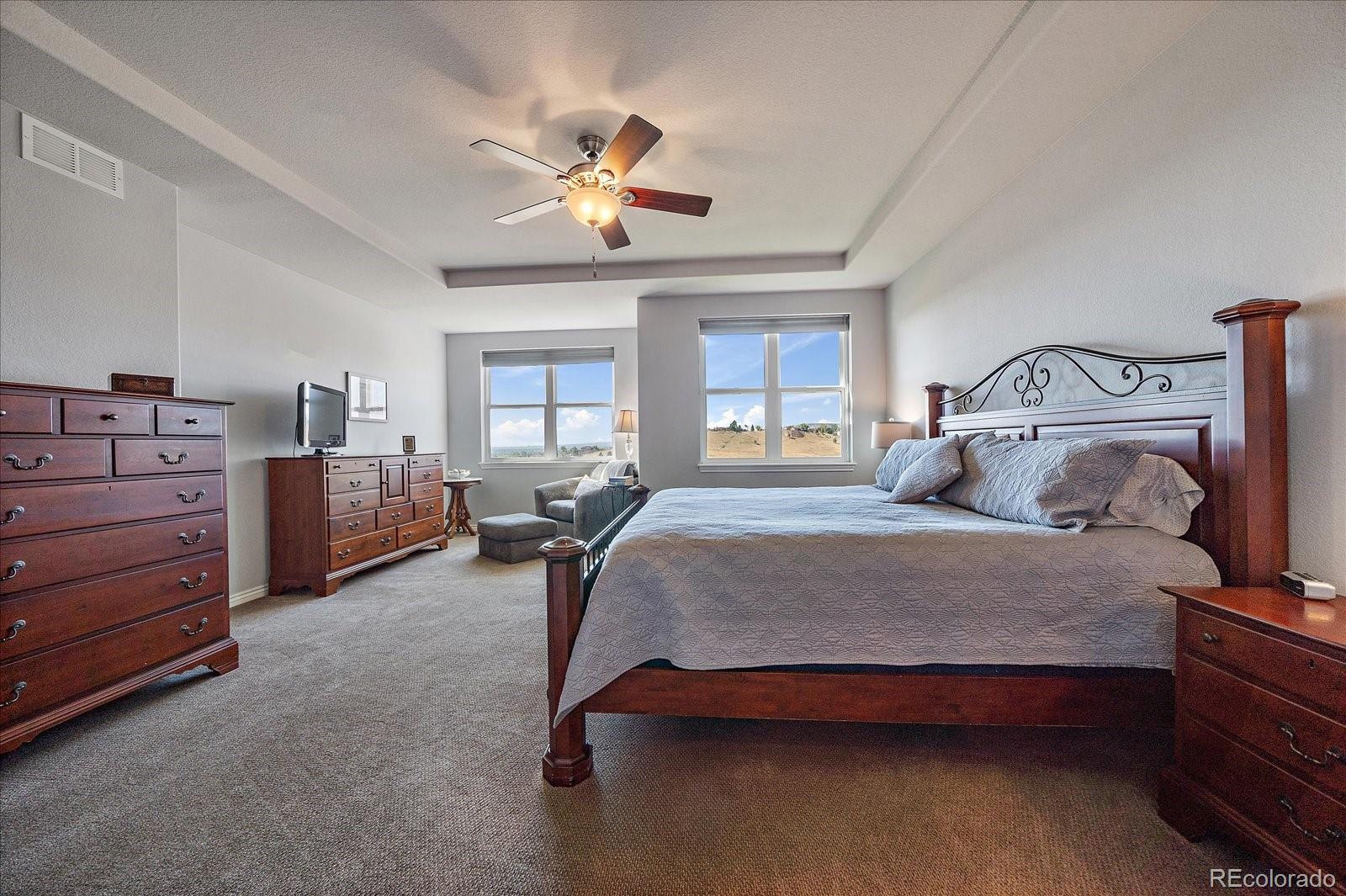 8412 Quaker Circle Arvada, CO 80007 - Photo 20 of 44 a bedroom with a bed and a chandelier