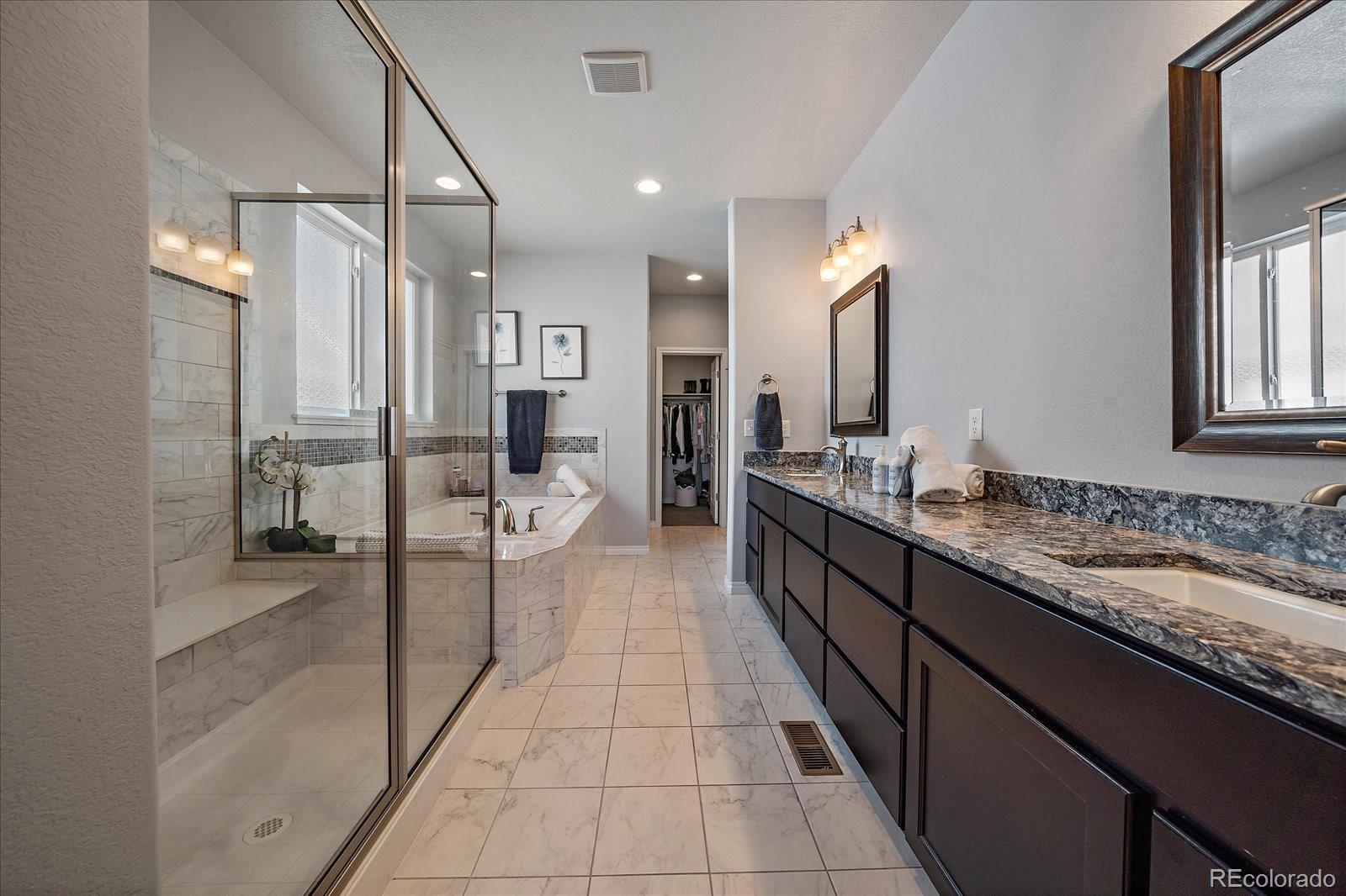 8412 Quaker Circle Arvada, CO 80007 - Photo 21 of 44 a large bathroom with a double vanity sink and a mirror