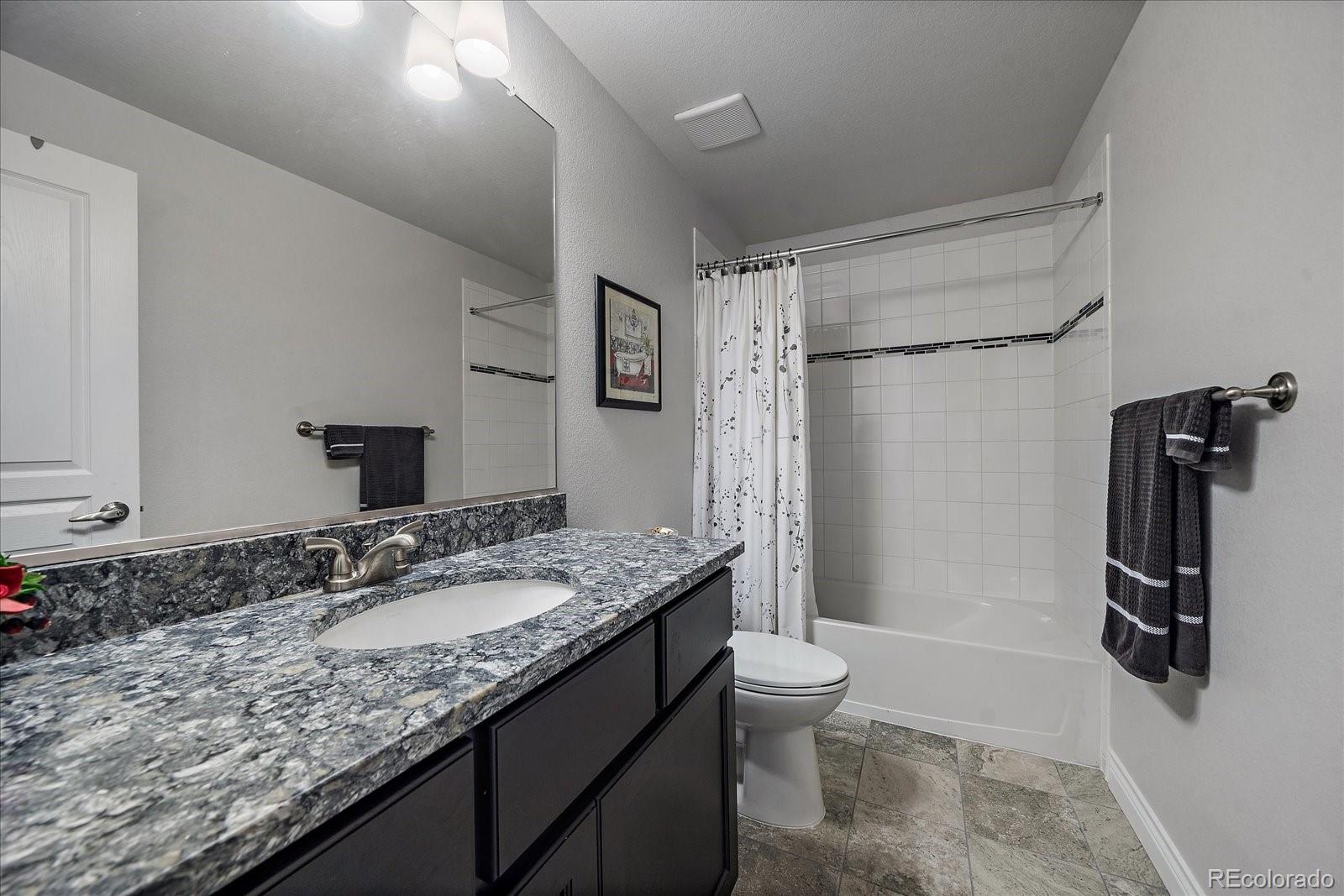 8412 Quaker Circle Arvada, CO 80007 - Photo 31 of 44 a bathroom with a granite countertop sink toilet and shower