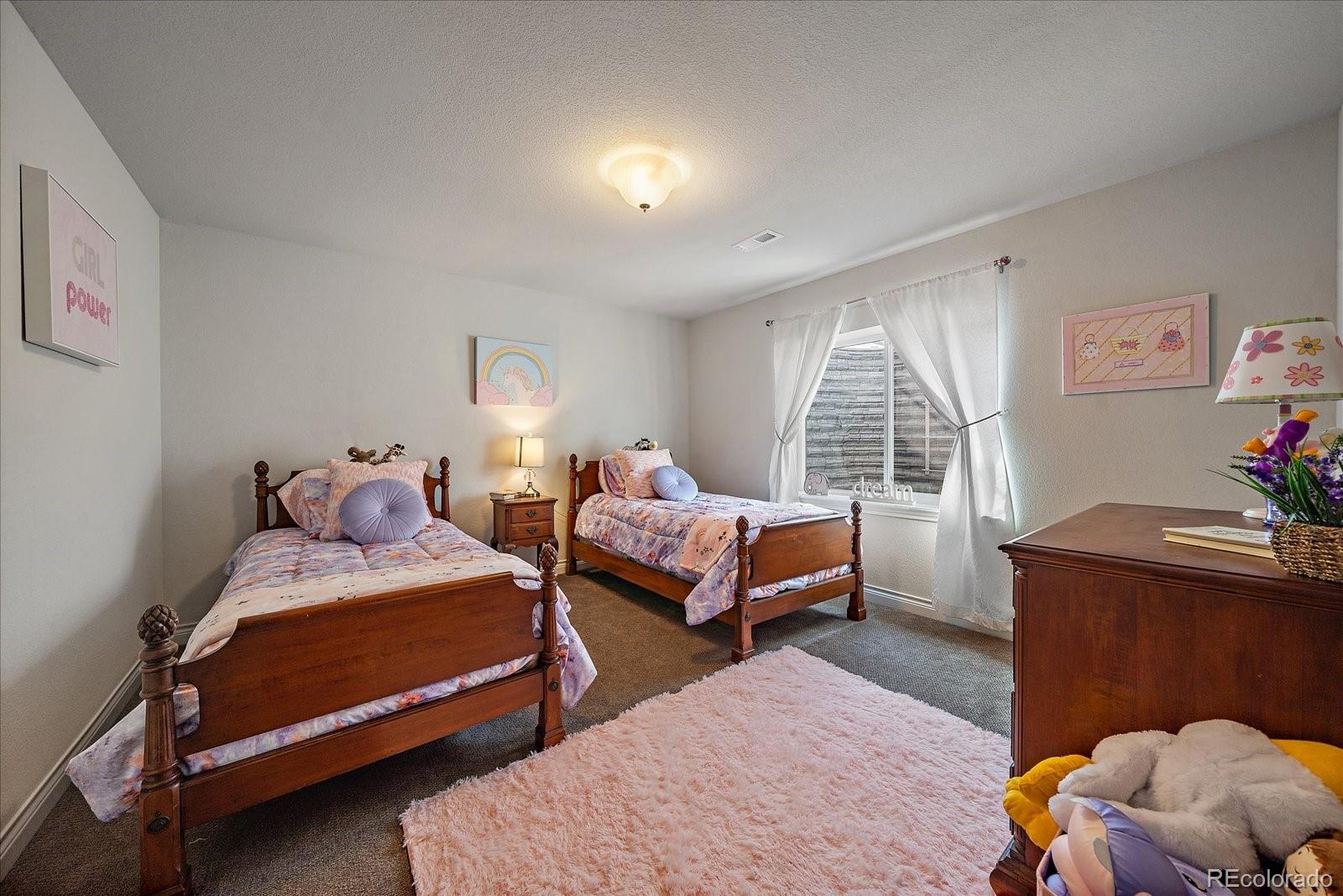8412 Quaker Circle Arvada, CO 80007 - Photo 32 of 44 a bedroom with two beds and a window