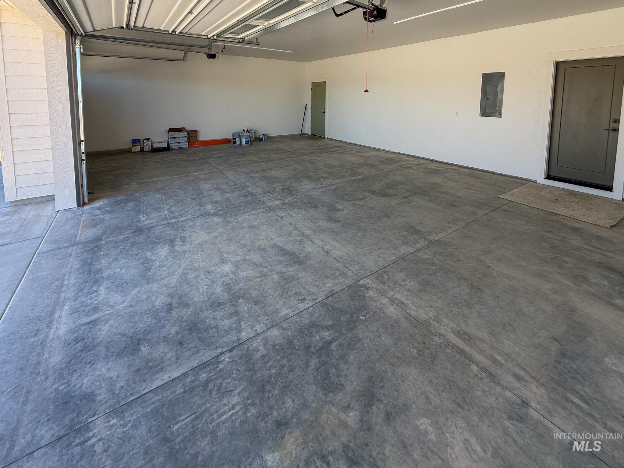 1108 Sage Rupert, ID 83350 - Photo 18 of 21 Spacious garage featuring a concrete floor, overhead garage door, and two pedestrian doors