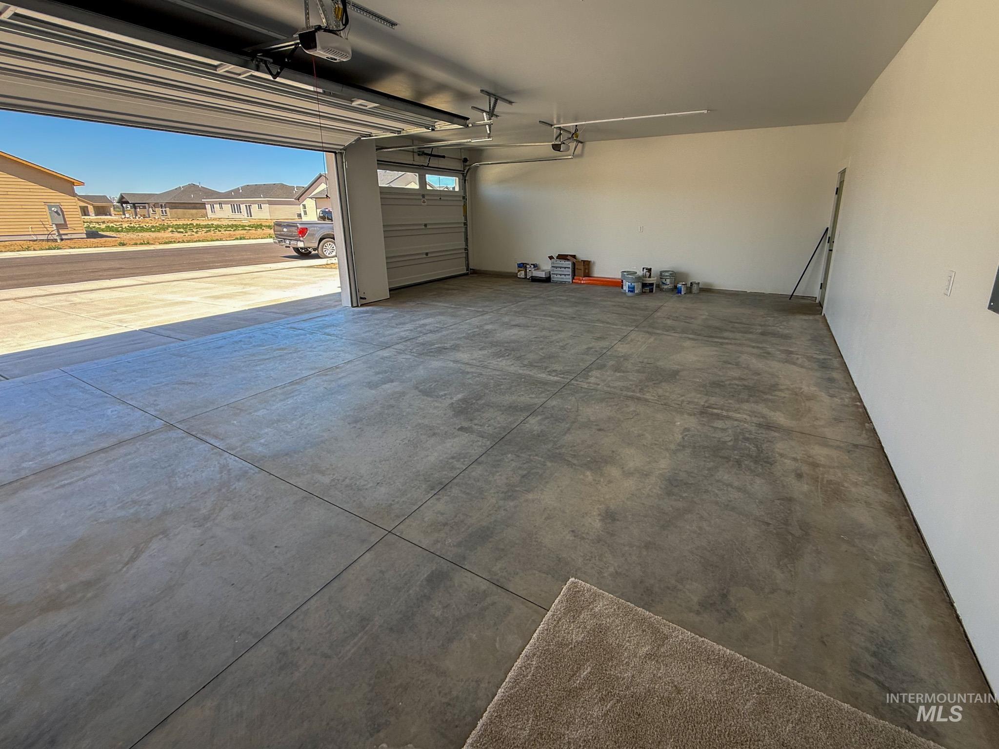 1108 Sage Rupert, ID 83350 - Photo 19 of 21 Spacious two-car garage featuring a concrete floor, painted walls, and an automatic garage door opener