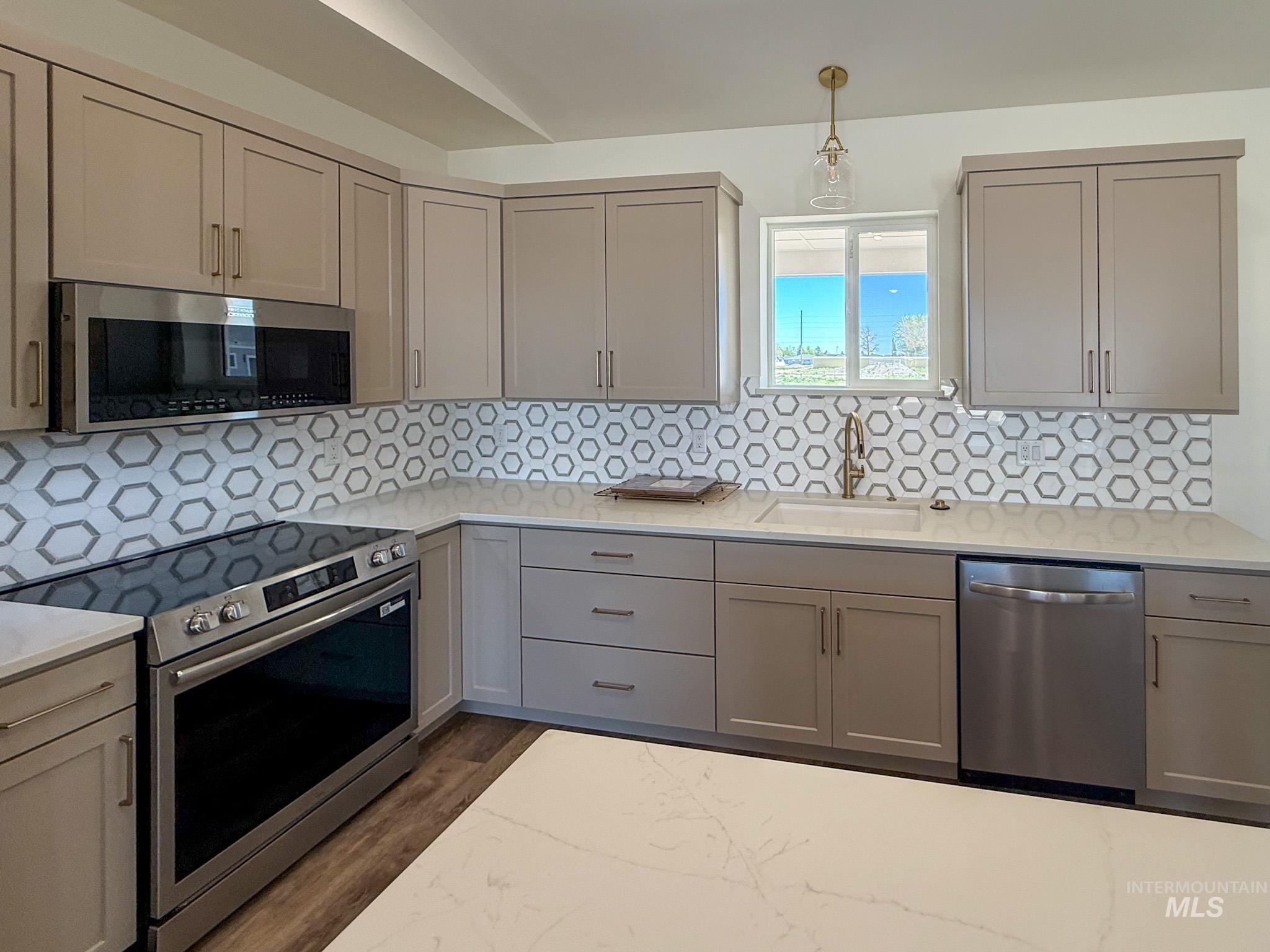 1108 Sage Rupert, ID 83350 - Photo 3 of 21 Kitchen featuring a stainless steel oven and built-in microwave, light gray cabinetry, hexagon tile backsplash, and light-toned countertops