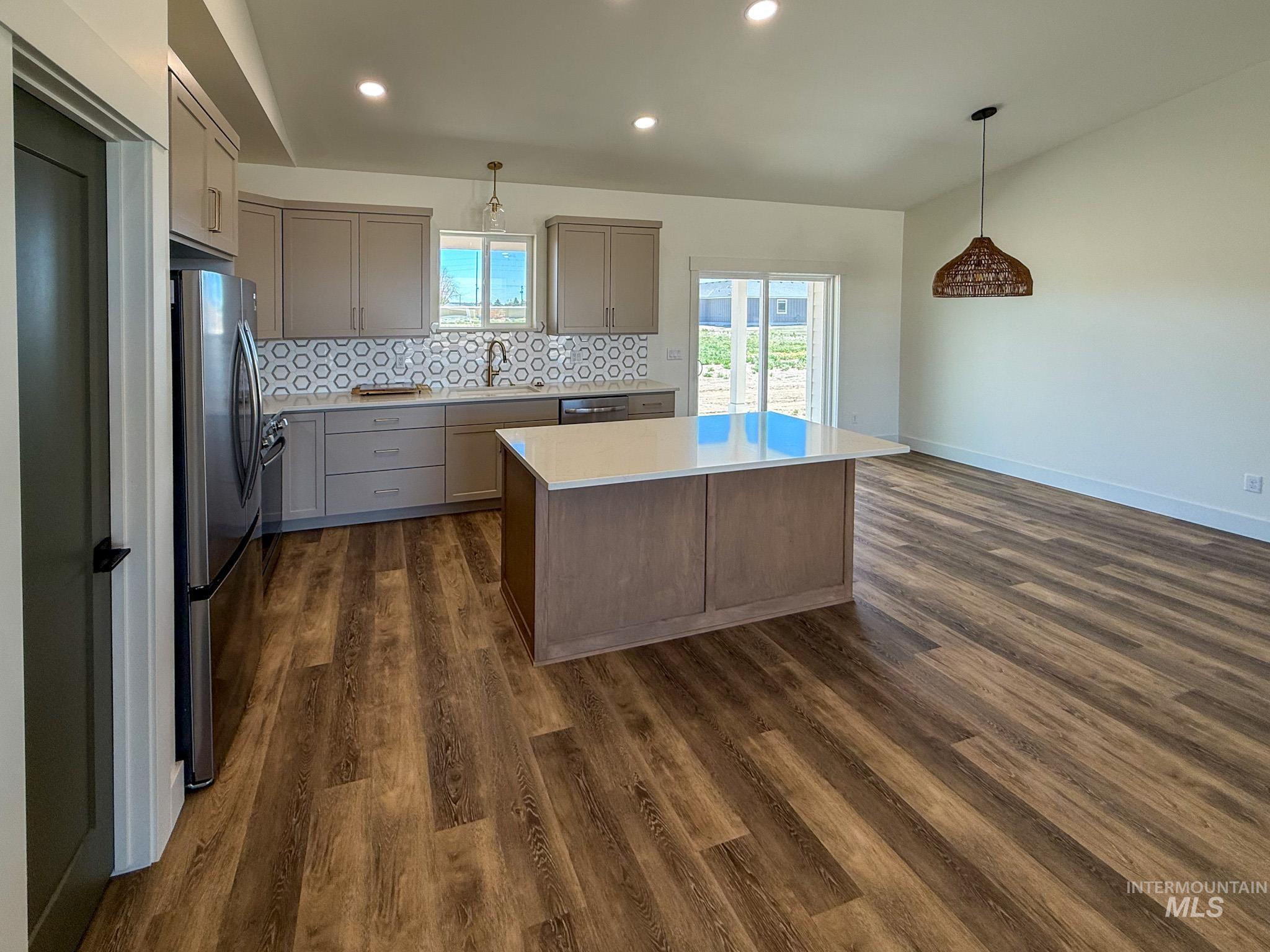 1108 Sage Rupert, ID 83350 - Photo 4 of 21 Kitchen featuring wood-finish flooring, a central island with a light-toned countertop, and light-toned cabinetry