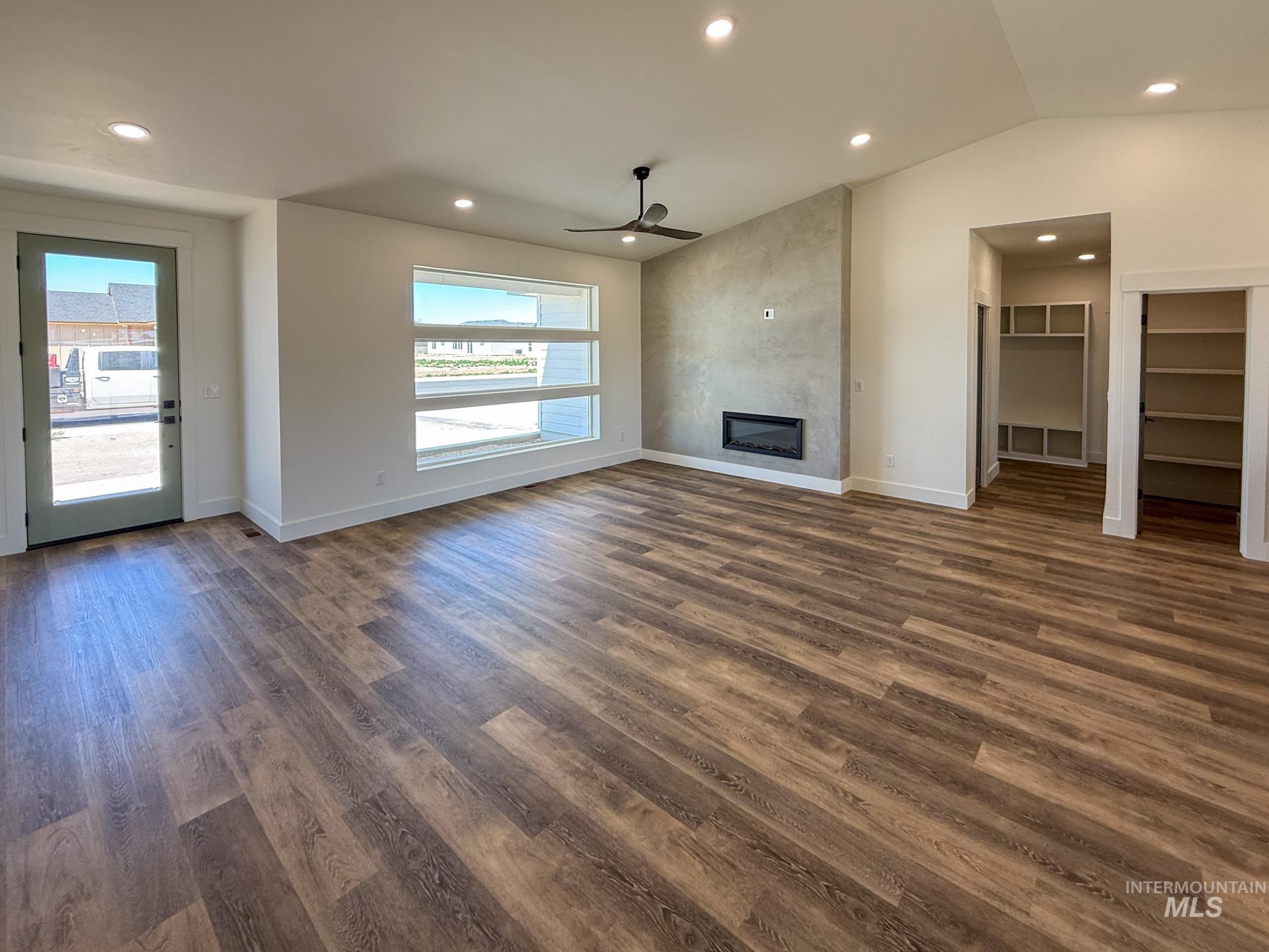 1108 Sage Rupert, ID 83350 - Photo 7 of 21 Spacious living area featuring wood-finish flooring, a contemporary linear fireplace with a textured accent wall, and a multi-pane horizontal window