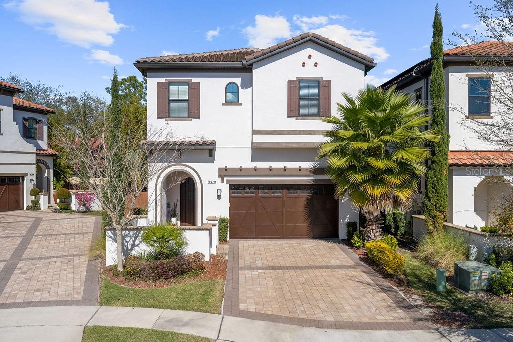 Front elevation...featuring brick paver driveway and mature landscaping