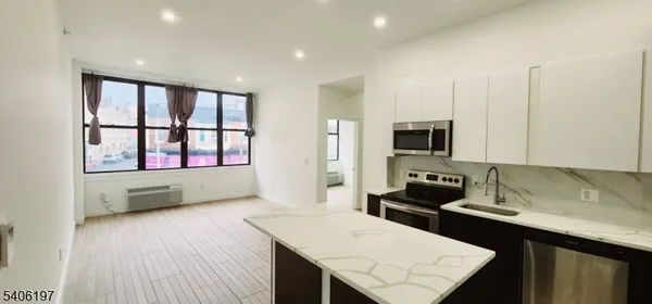 a kitchen with stainless steel appliances kitchen island granite countertop a stove a sink and a microwave