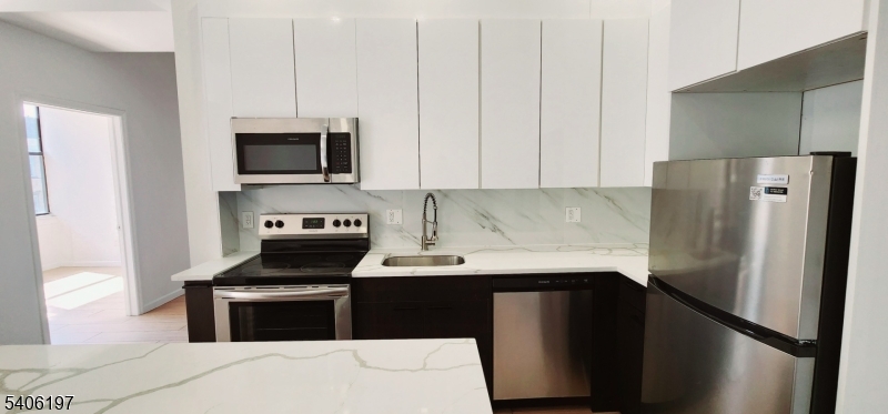 30 Howe Avenue Passaic, NJ 07055 - Photo 6 of 10 a kitchen with a refrigerator stove and microwave