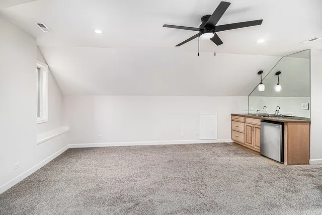 a view of a kitchen island a sink and refrigerator
