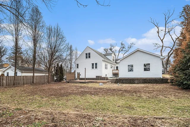 a view of a white house with a yard covered in snow