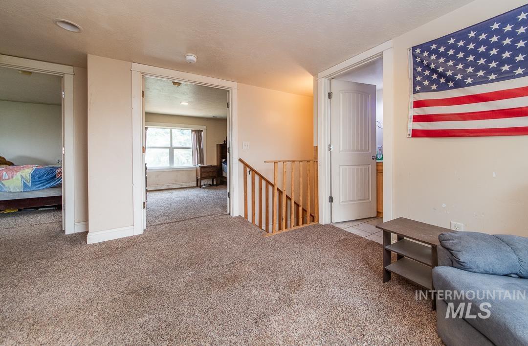 595 Cemetery Road Cambridge, ID 83610 - Photo 24 of 47 Carpeted landing area featuring a wooden staircase and three distinct doorways
