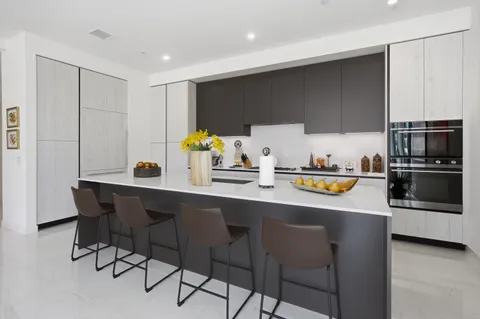 a kitchen with stainless steel appliances a sink a stove a microwave a refrigerator and cabinets