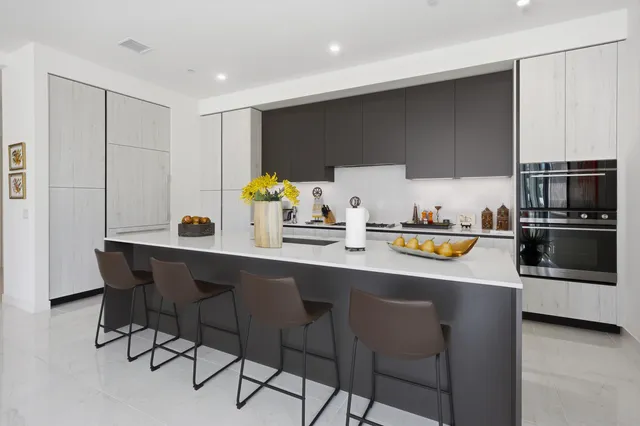 a kitchen with stainless steel appliances a sink a stove a microwave a refrigerator and cabinets