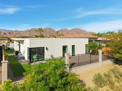 a view of a terrace with a garden and couches chairs