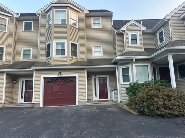 a front view of a house with yard and parking
