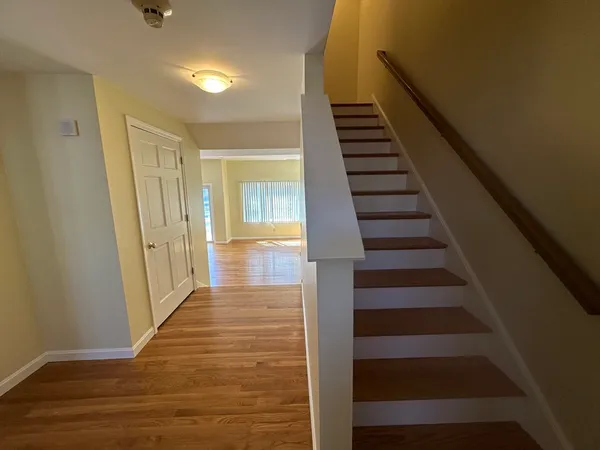 a view of a hallway with wooden floor and entryway
