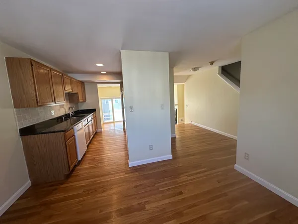 a kitchen with granite countertop wooden floors and wide window