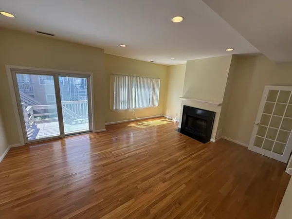 an empty room with wooden floor and fireplace