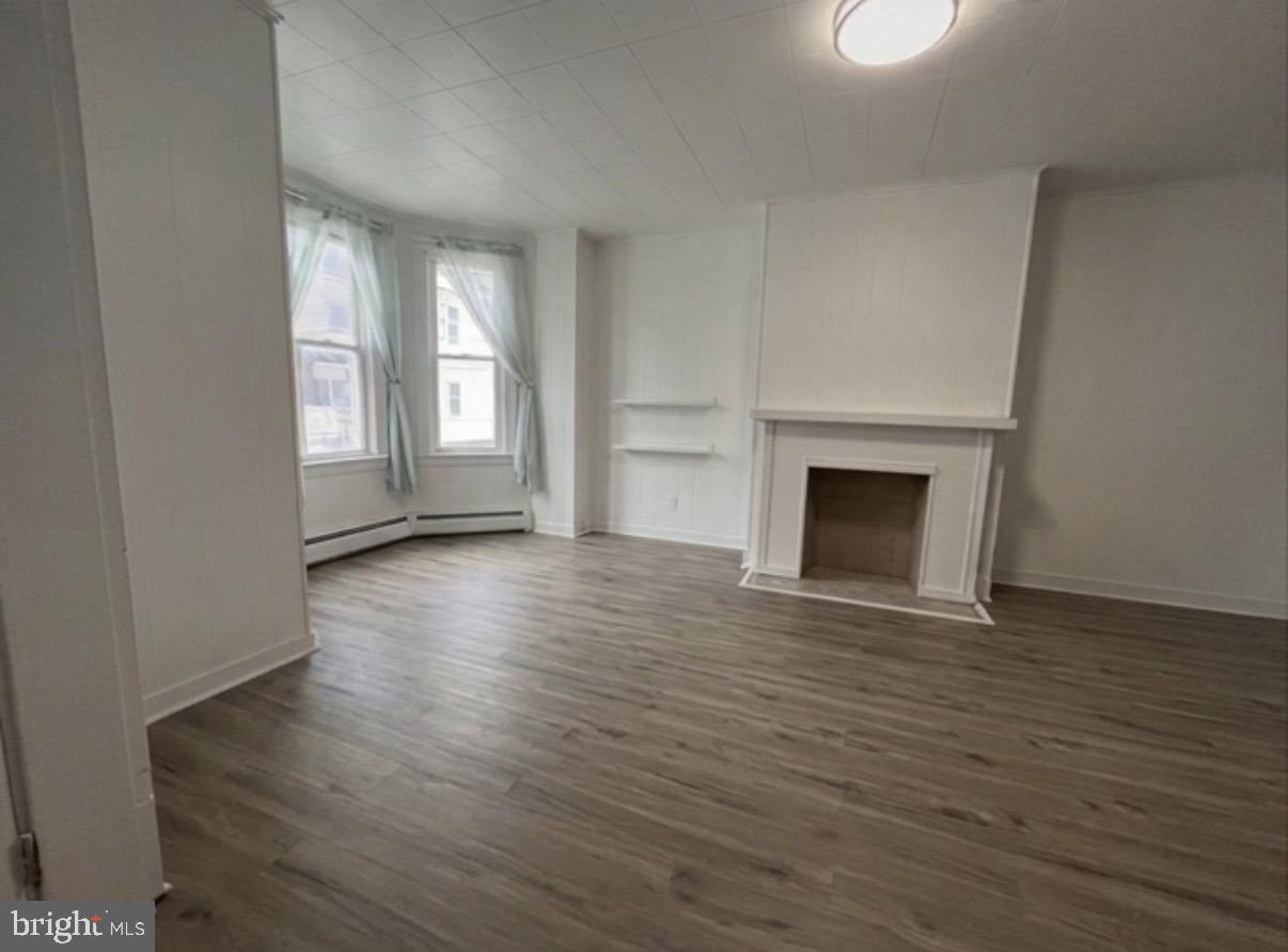 8 South Maple Avenue Brunswick, MD 21716 - Photo 13 of 13 an empty room with wooden floor fireplace and windows