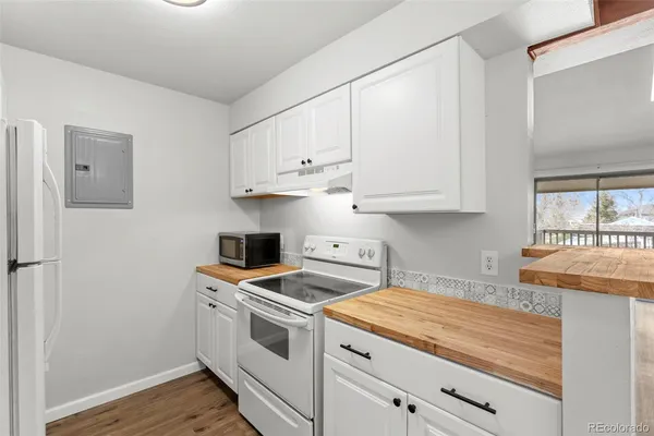a kitchen with granite countertop white cabinets and white appliances