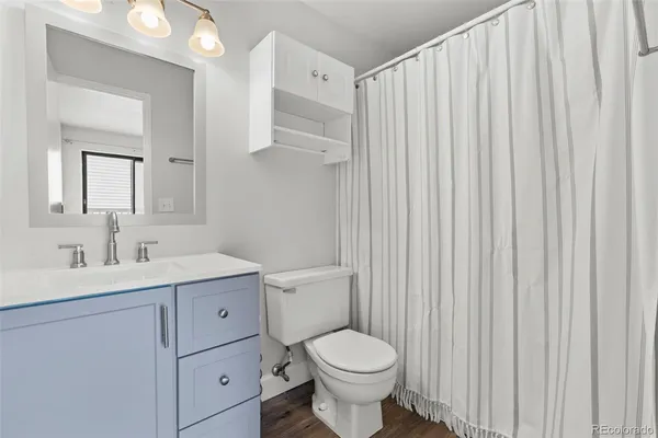 a bathroom with a toilet a sink a vanity and mirror