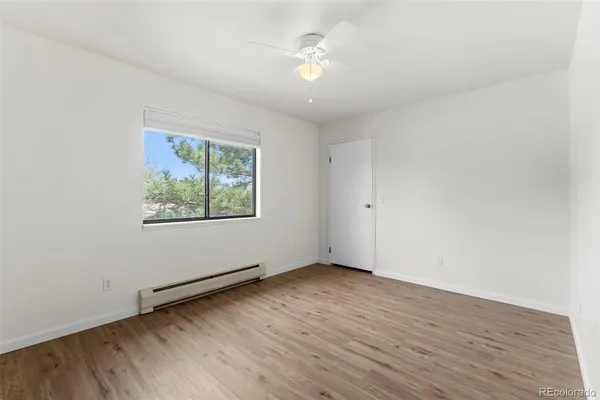 an empty room with wooden floor and windows