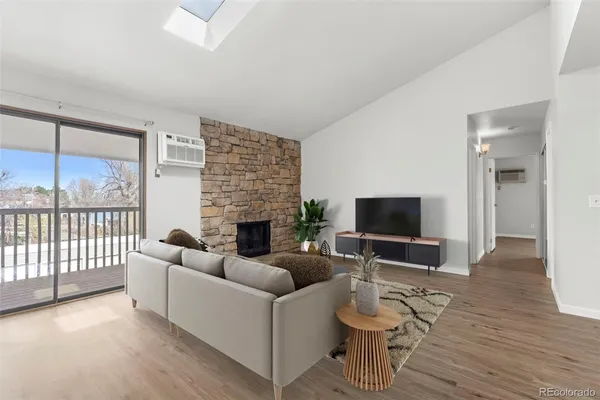 a living room with furniture a flat screen tv and a floor to ceiling window