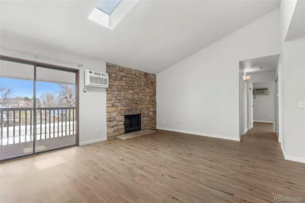 wooden floor fireplace and windows in an empty room