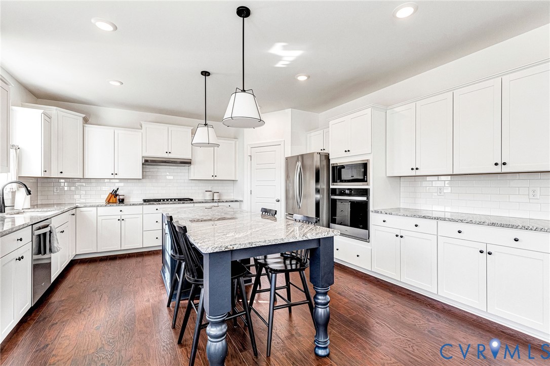 17101 Westington Road Moseley, VA 23120 - Photo 12 of 50 a kitchen with white cabinets stainless steel appliances and wooden floor
