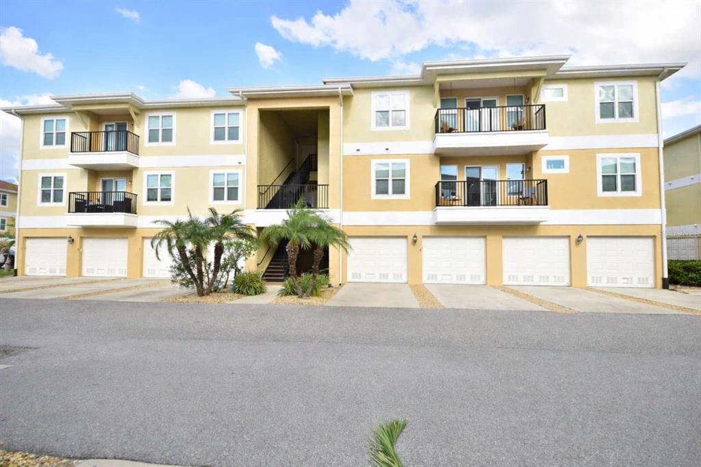 6420 Banyan Boulevard, Unit 303 New Port Richey, FL 34652 - Photo 2 of 54 a front view of a residential apartment building with a yard and potted plants