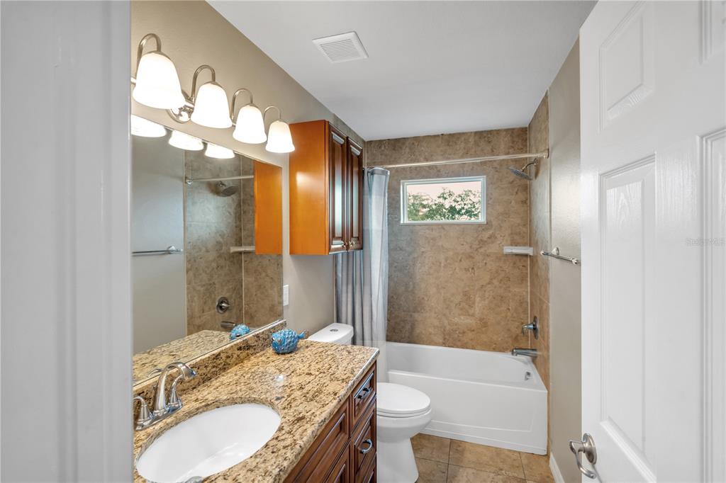 6420 Banyan Boulevard, Unit 303 New Port Richey, FL 34652 - Photo 25 of 54 a bathroom with a granite countertop tub sink and a mirror