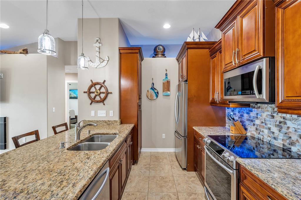 6420 Banyan Boulevard, Unit 303 New Port Richey, FL 34652 - Photo 7 of 54 a kitchen with stainless steel appliances granite countertop a sink stove and refrigerator
