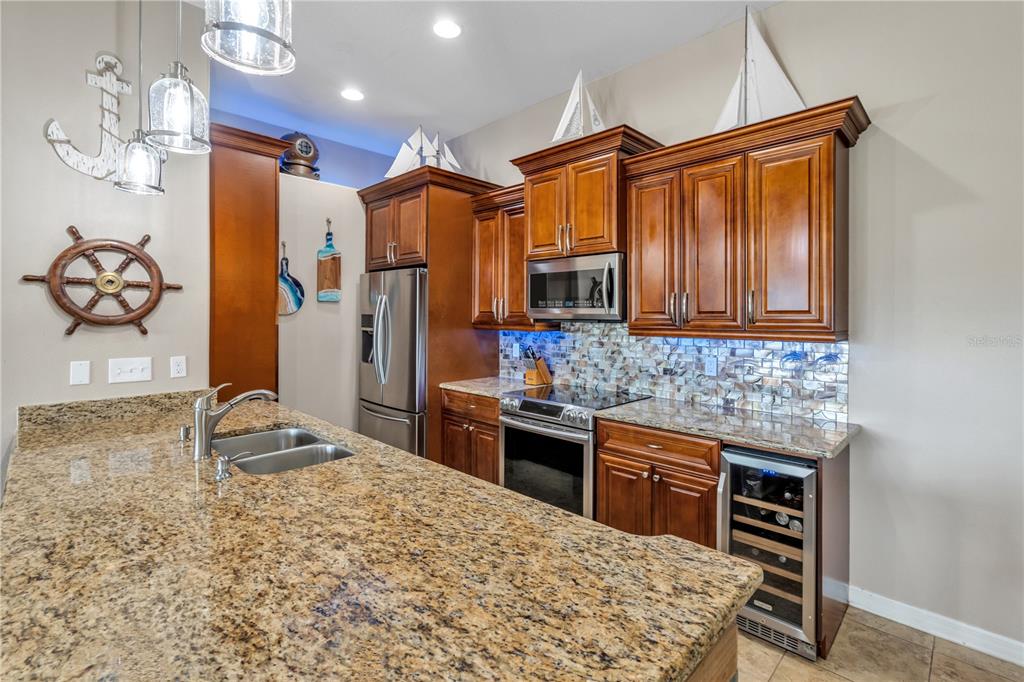 6420 Banyan Boulevard, Unit 303 New Port Richey, FL 34652 - Photo 8 of 54 a kitchen with stainless steel appliances granite countertop a sink stove and refrigerator