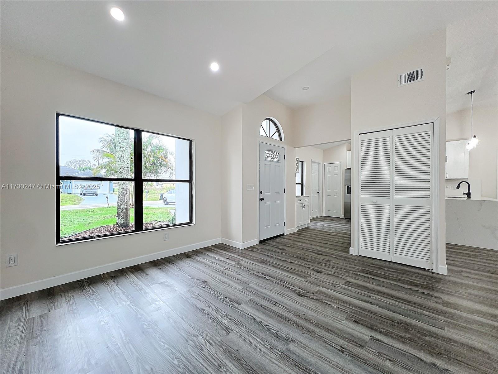 521 Southwest Rabbit Avenue Port St. Lucie, FL 34953 - Photo 15 of 45 an empty room with wooden floor and windows